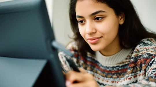 Étudiante en webdesign travaillant sur une tablette graphique dans un espace créatif moderne avec vue sur la ville