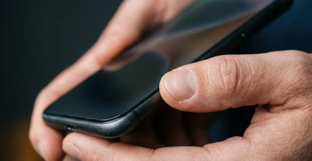 Gros plan sur des mains tenant un smartphone avec des éléments visuels abstraits de progression d'apprentissage