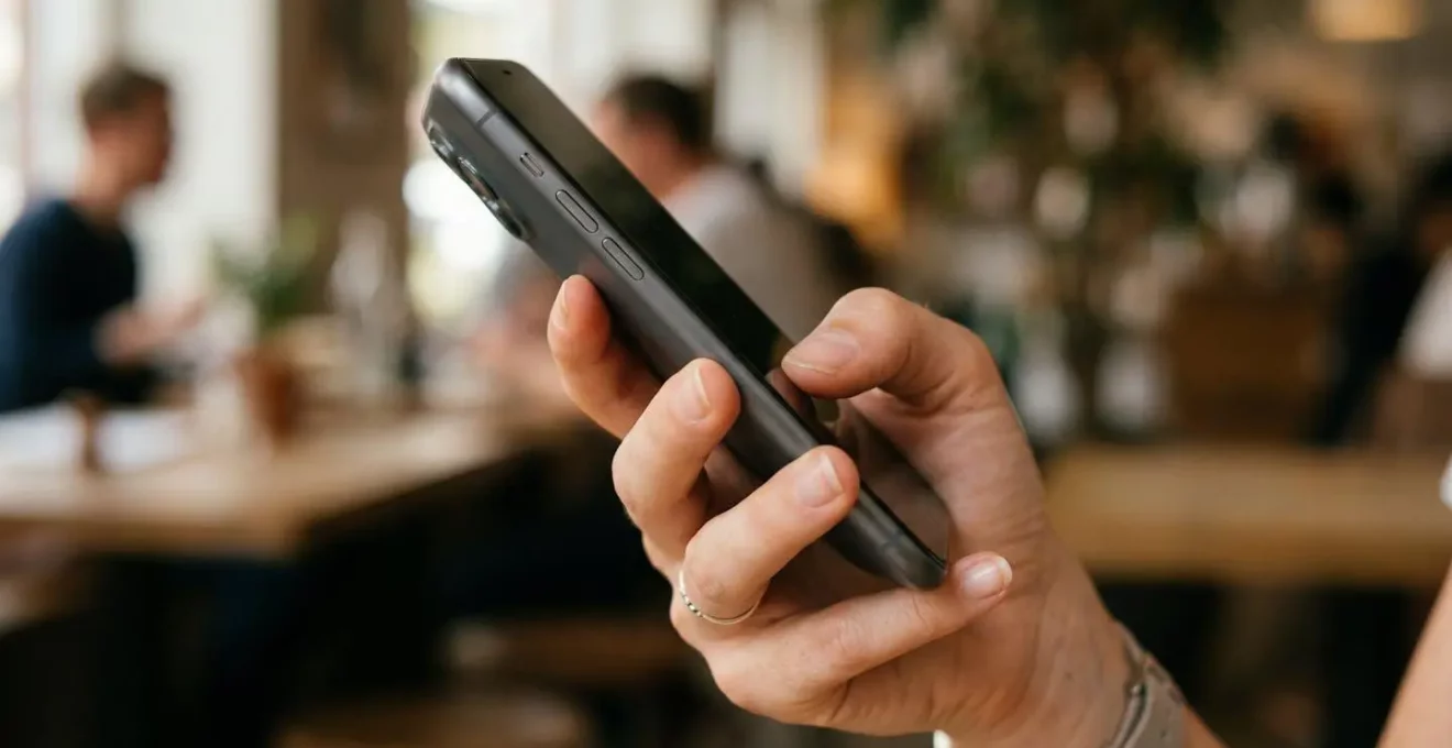 Vue rapprochée d'une main tenant un smartphone montrant une navigation mobile intuitive
